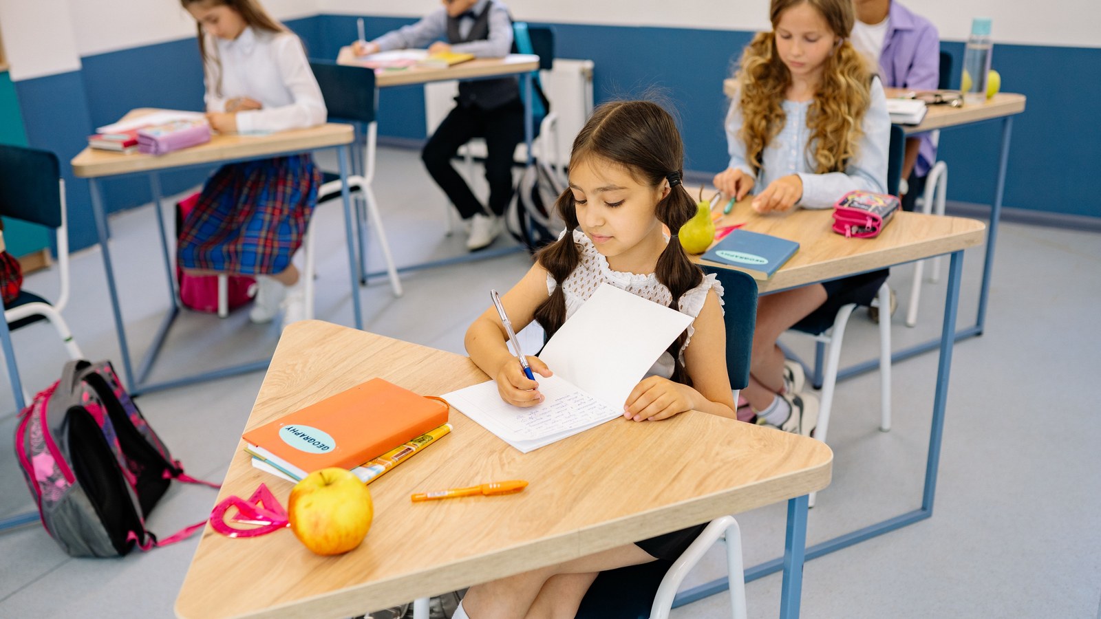 Pupils writing independently at desks in a classroom
